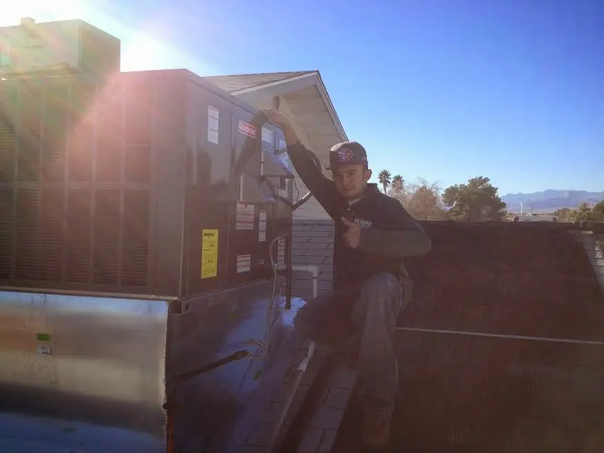HVAC technician performing HVAC Inspection on a rooftop unit in Fort Stewart